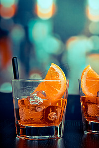酒吧桌上放着一杯 spritz 开胃酒 aperol 鸡尾酒，配有橙片和冰块，流行风格的氛围背景
