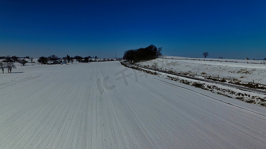 新鲜的雪落在有铁路轨道的农田上
