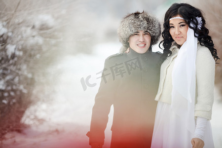 冬季婚礼，异国情调的亚洲新婚夫妇，戴着裘皮帽的新郎，穿着冬衣的新娘。