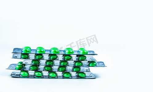 成堆的绿色圆形糖衣药丸，装在白色背景的泡罩包装中，带有复制空间。