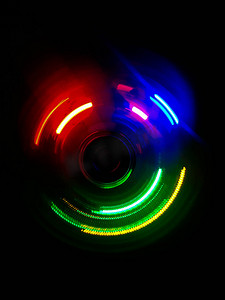 彩色光波摄影照片_深色背景中的彩色圆形光波