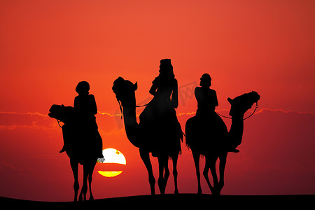 日落时骑骆驼的人