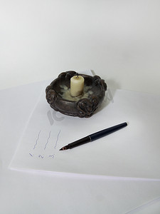 蜡烛，羽毛笔在纸堆上。
