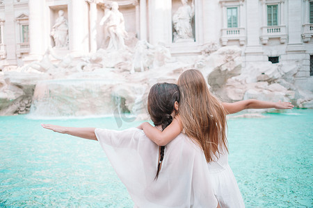 古代钱币摄影照片_母亲和小女孩在罗马特莱维喷泉。