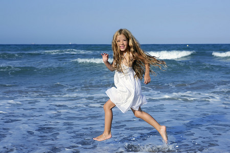 蓝色大海中奔跑沙滩的小女孩