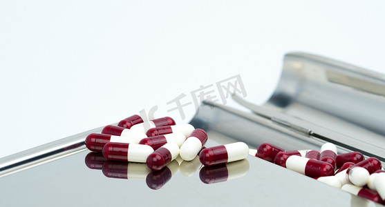 五颜六色的抗生素胶囊药片在不锈钢药盘上有阴影，耐药性概念。