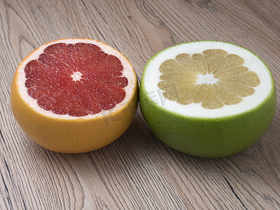 一半的绿色甜心和红色葡萄柚木制背景上。