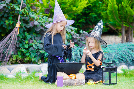 万圣节快乐的小女巫们在户外玩得很开心。