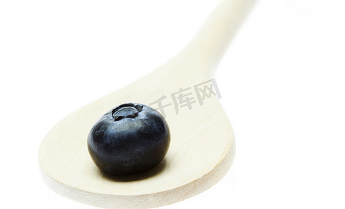蓝莓味道摄影照片_用白色隔开的木勺中的蓝莓