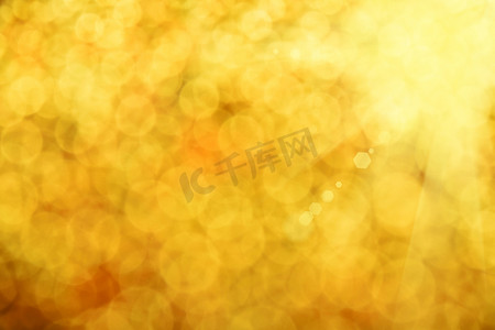 闪金色的光摄影照片_金色闪光光夏天抽象模糊背景