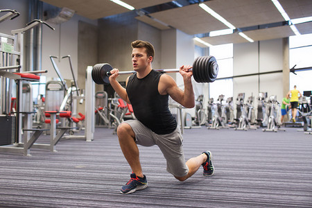 年轻人在健身房用杠铃锻炼肌肉