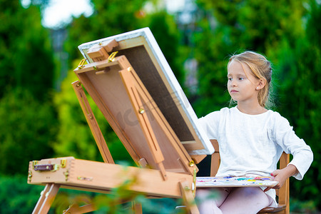 可爱的小女孩在户外画架上画画