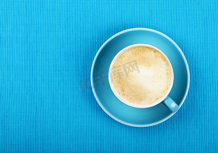蓝杯顶视图中的全卡布奇诺拿铁咖啡