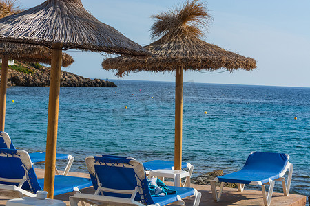 带伞摄影照片_蓝色的大海，马略卡岛上带伞的海滩。