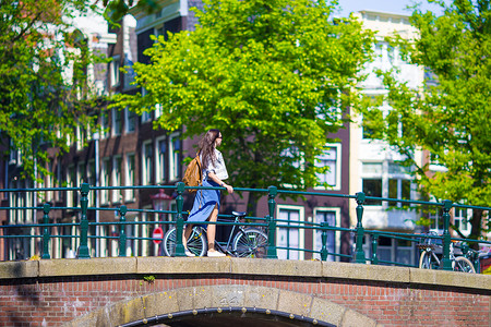 旅游杂志摄影照片_走在欧洲城市，阿姆斯特丹，荷兰的年轻美女