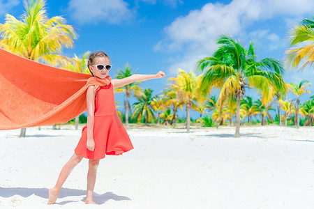 在热带海滩扮演超级英雄的小可爱女孩