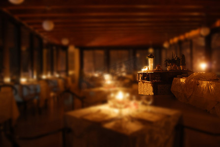 昏暗的餐厅摄影照片_在烛光下布置餐厅的桌子