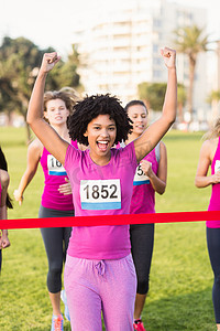 为赢得乳腺癌马拉松比赛而欢呼的年轻女子