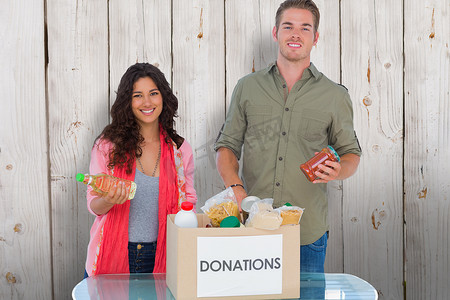 微笑的志愿者从捐款箱中取出食物的合成图像
