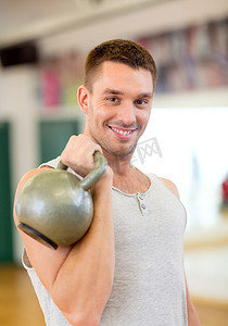 带着壶铃在健身房微笑的男人