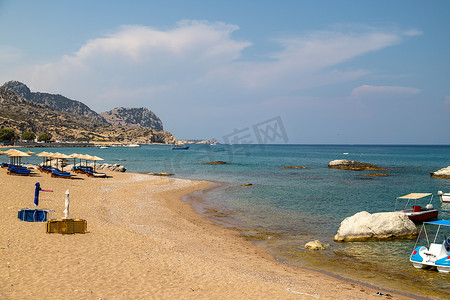在希腊海岛罗得岛的 Stegna 海滩有沙子、遮阳伞和蟒蛇的