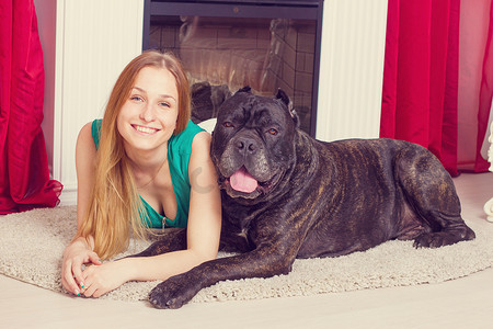 女孩和他的大狗 Cane Corso 在壁炉旁的家里