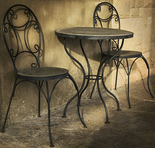 墙上的影子摄影照片_街头咖啡馆里有两把椅子的桌子