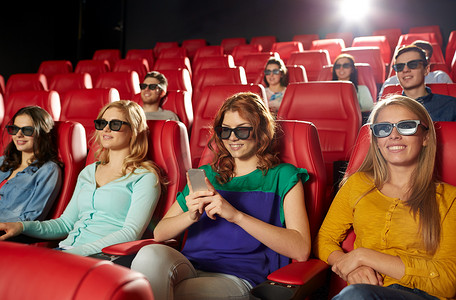 3d 电影院里拿着智能手机的快乐女人
