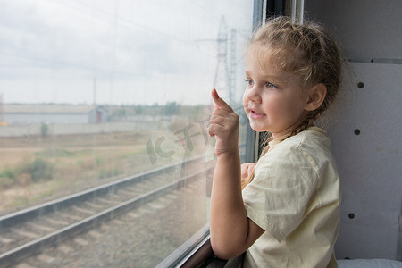 四岁女孩从火车车厢的窗户伸出手指