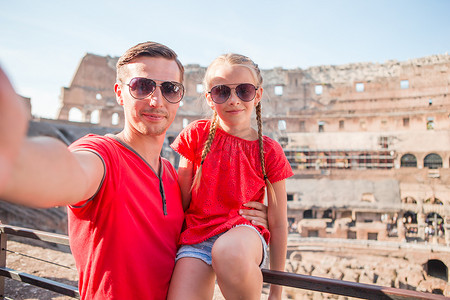 年轻的父亲和小女孩在罗马的主要旅游景点体育馆自拍。