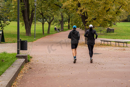 2020 年秋季，捷克共和国冬季开始时，由于 COVID-19 爆发，在隔离期间，男人和女人在布拉格 6 号的 Letna 公园跑步和交谈