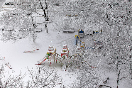 儿童娱乐设施摄影照片_被雪覆盖的废弃儿童游乐场