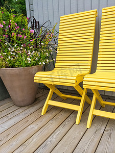 用黄色椅子和鲜花装饰的露台