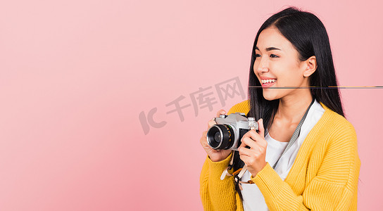 拿着复古老式照片相机的女人兴奋地微笑着摄影师