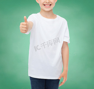 男t摄影照片_穿着白色 T 恤并竖起大拇指的男孩的特写
