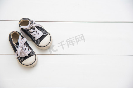 鞋背景黑摄影照片_木地板上的儿童黑鞋