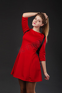 一个身穿红色连衣裙、背着黑色皮背包的女孩的画像