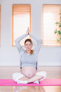 在运动垫上做瑜伽的孕妇