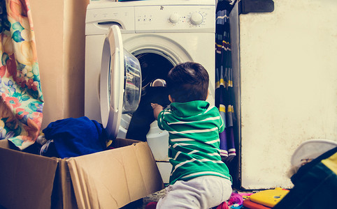 一岁半男婴把衣服放进洗衣机