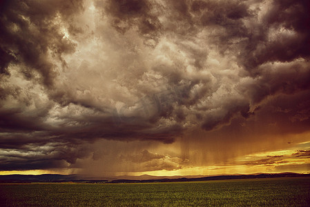 草地下雨摄影照片_戏剧性的场景——有云有雨的草地