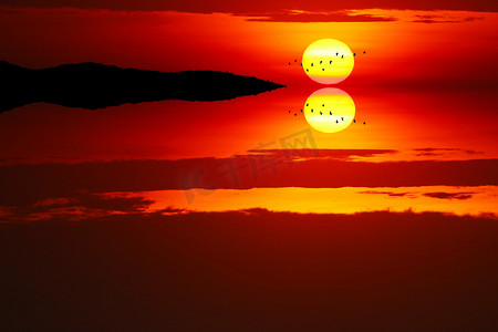 金色回家摄影照片_夕阳反射在傍晚的光云上，天空和鸟儿飞回家