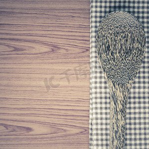 木质背景中带勺子的厨房毛巾
