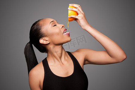 快乐健康的亚洲黑人女性榨橙汁水果