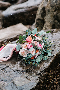 婚礼背景板摄影照片_牡丹的婚礼花束与石头上的丝带