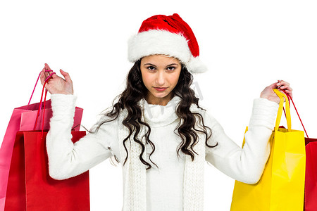 圣诞衣服摄影照片_戴着圣诞帽、拿着彩色购物袋的女人
