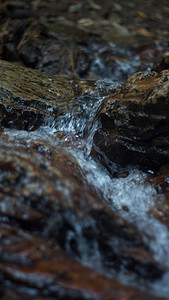 火焰蓝摄影照片_山河在风景如画的夏日石之间流动的特写