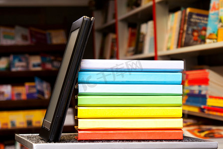 堆有电子书阅读器的五颜六色的书