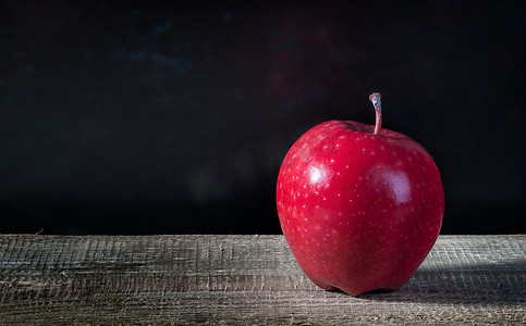在一张木桌上的唯一苹果