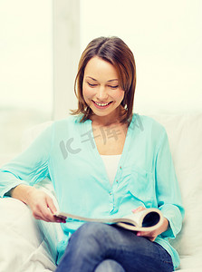 微笑的女人在家看杂志