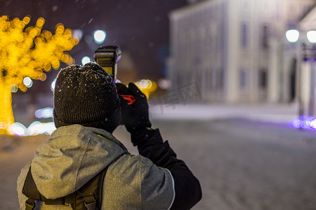 专业摄影师在多雪的冬天用自然光和选择性聚焦拍摄夜景建筑